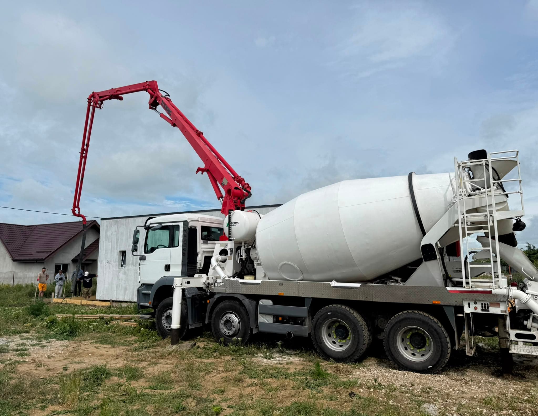 Autopompă de beton SCHWING MNT Grup cu brațul desfășurat, turnând beton pe șantier